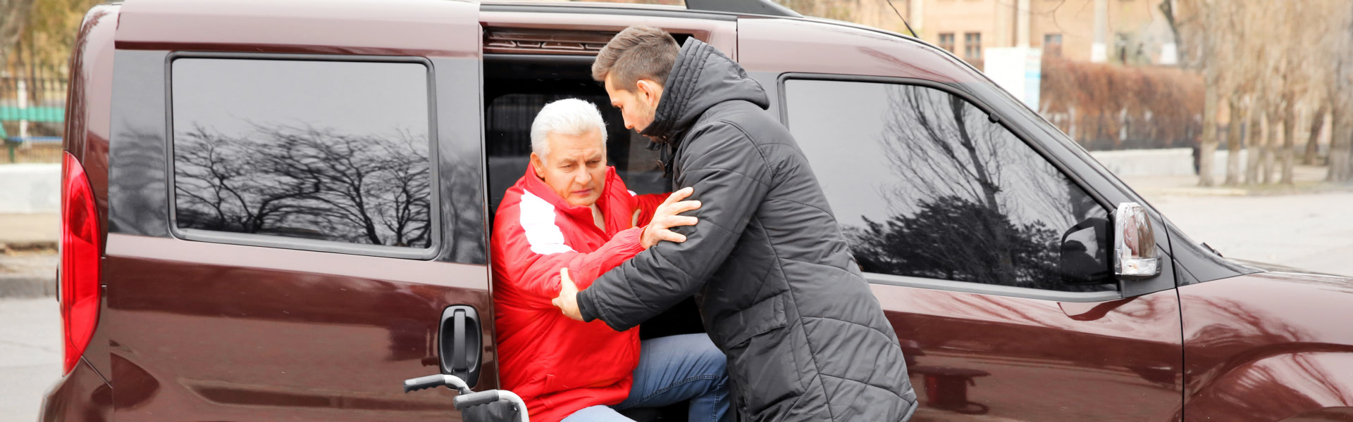 caregiver assist his patient in stepping out the car